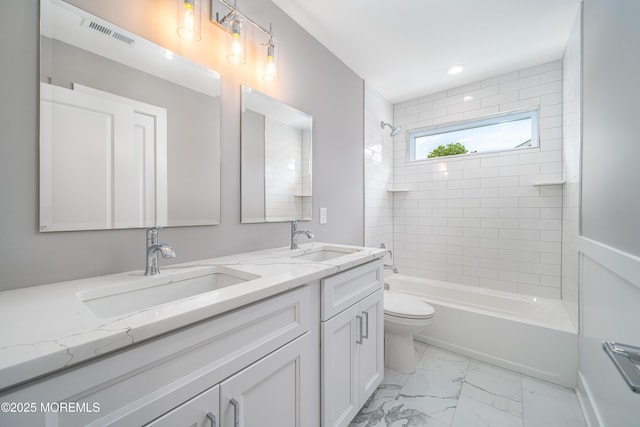 full bathroom with vanity, toilet, and tiled shower / bath