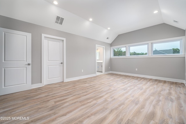 empty room featuring light wood-type flooring and lofted ceiling