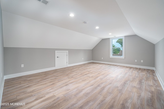 additional living space featuring recessed lighting, visible vents, baseboards, vaulted ceiling, and light wood finished floors