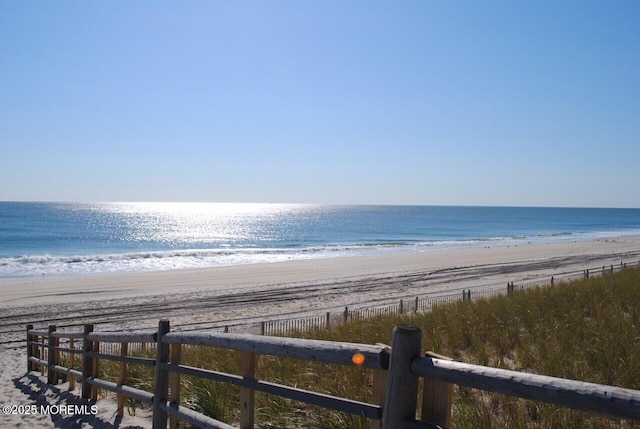 water view featuring a view of the beach and fence