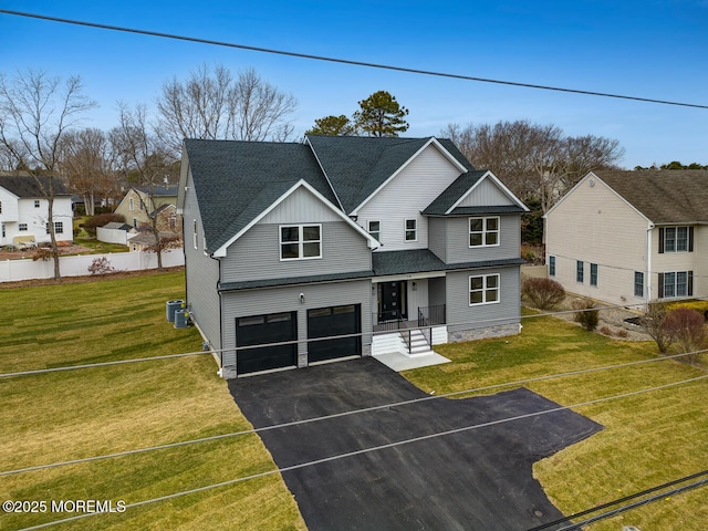 view of front of home with an attached garage, a shingled roof, a front lawn, and cooling unit