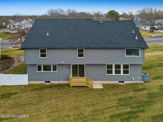 back of house featuring central AC unit, a shingled roof, fence, and a yard