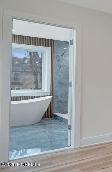 doorway with baseboards and wood finished floors