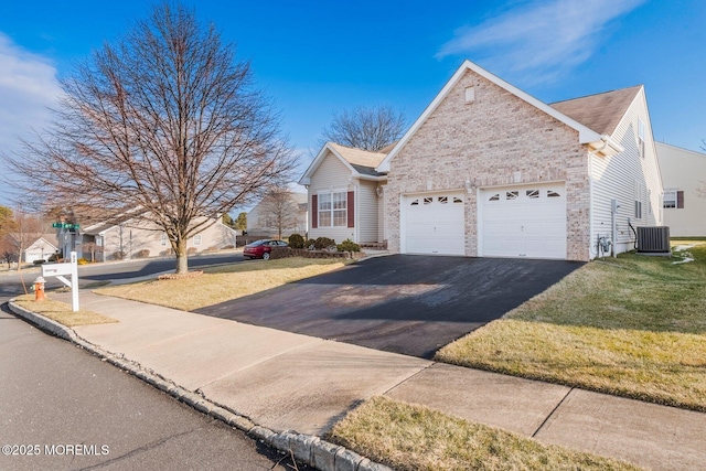 view of front of property featuring a front lawn, cooling unit, and a garage