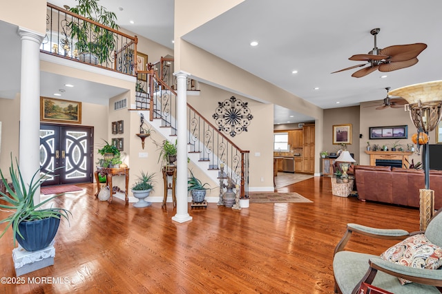 living room with french doors, light hardwood / wood-style floors, decorative columns, and ceiling fan