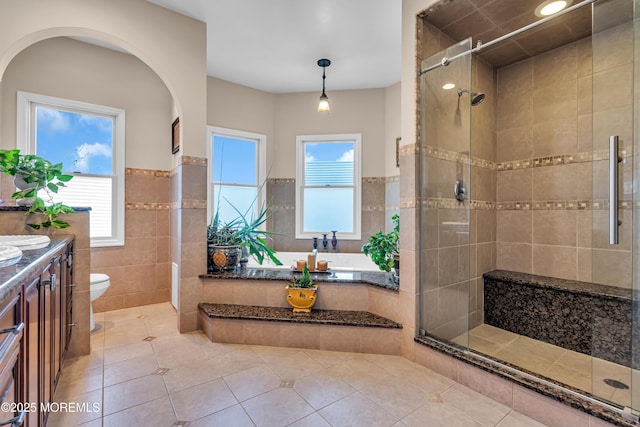 full bathroom with toilet, separate shower and tub, tile patterned floors, and tile walls