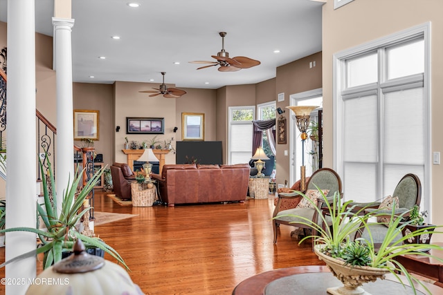 living room featuring ornate columns, ceiling fan, and light hardwood / wood-style floors