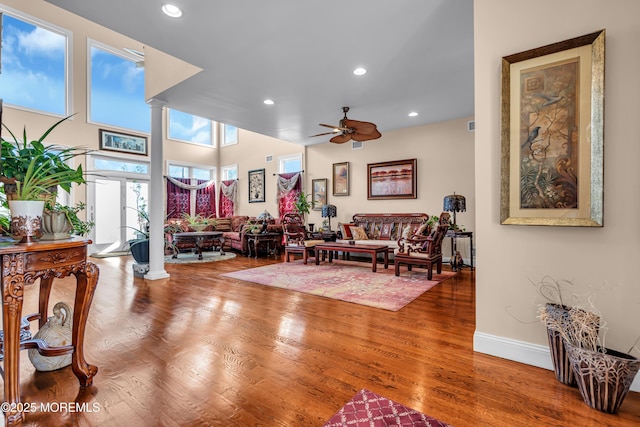 living room featuring ornate columns, ceiling fan, and hardwood / wood-style floors