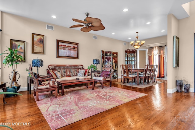 living room featuring hardwood / wood-style floors and ceiling fan with notable chandelier