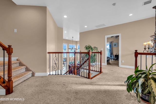 corridor featuring a chandelier and carpet flooring