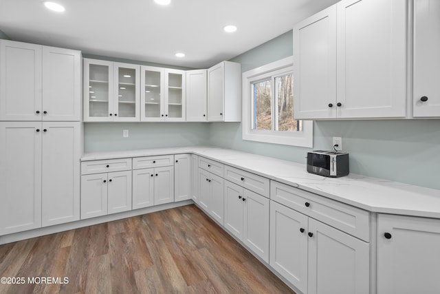 kitchen featuring light stone countertops, white cabinets, and dark wood-type flooring