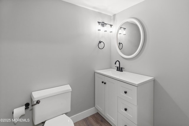 bathroom with wood-type flooring, vanity, and toilet