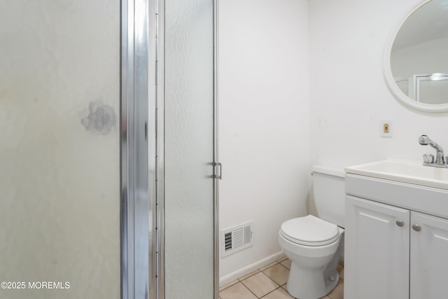 bathroom with toilet, vanity, tile patterned floors, and a shower with door