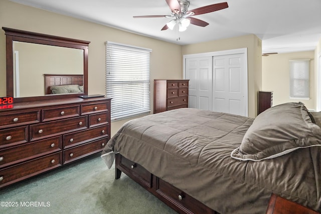 bedroom with dark colored carpet, ceiling fan, and a closet