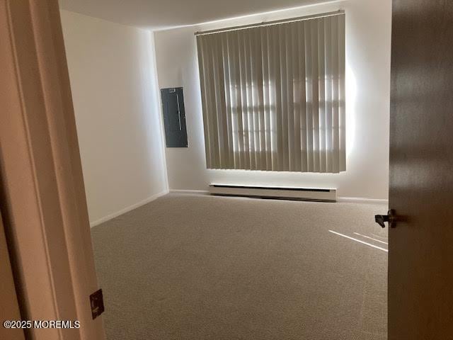 carpeted empty room with electric panel and a baseboard radiator