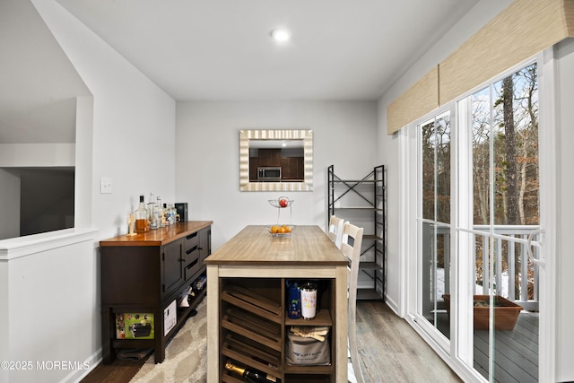 dining area with hardwood / wood-style flooring and bar