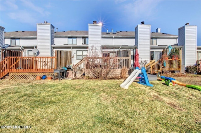 back of house featuring a deck and a lawn