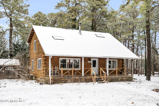 view of front of home with covered porch and a storage shed