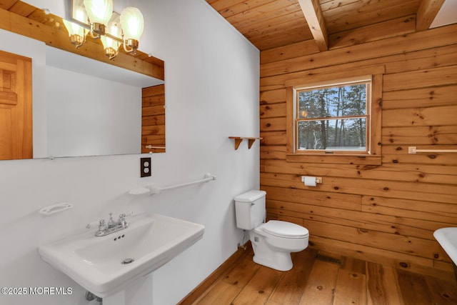 bathroom with sink, wood ceiling, and wood walls