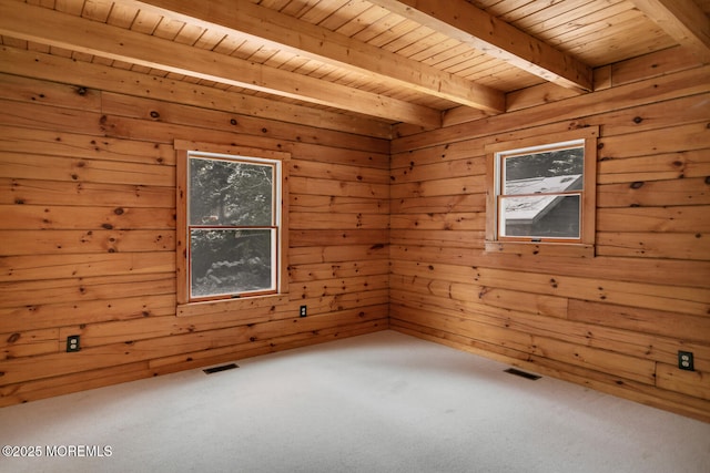 carpeted spare room featuring beam ceiling, wooden walls, and wood ceiling