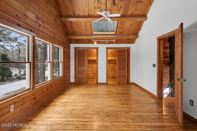 unfurnished sunroom with vaulted ceiling with beams, ceiling fan, and wooden ceiling