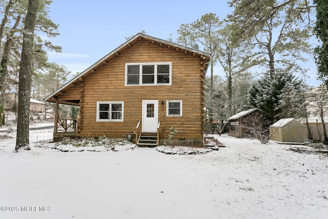 snow covered property with a storage shed