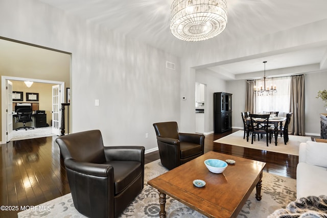 living room featuring an inviting chandelier, baseboards, visible vents, and hardwood / wood-style floors