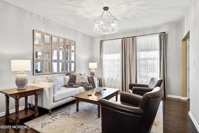 living room with dark hardwood / wood-style floors and a notable chandelier