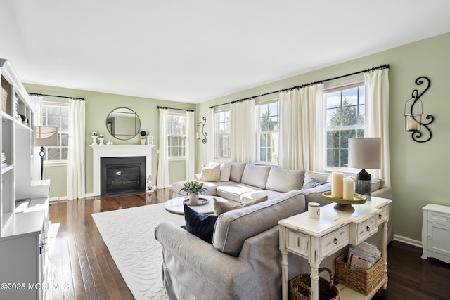 living area with a fireplace with flush hearth, dark wood-style flooring, and baseboards