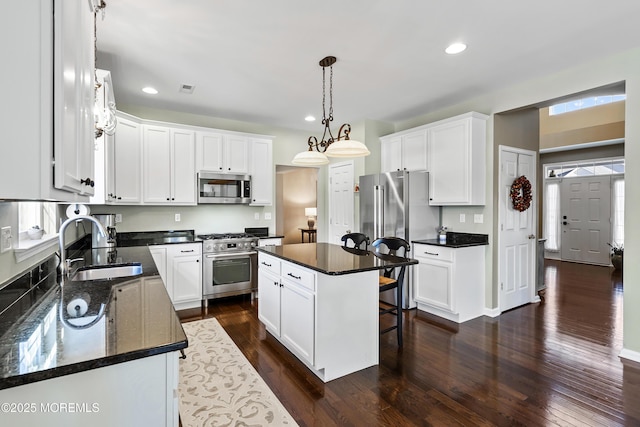 kitchen featuring premium appliances, white cabinetry, and a kitchen island