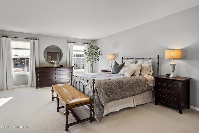 bedroom featuring light carpet, baseboards, and multiple windows