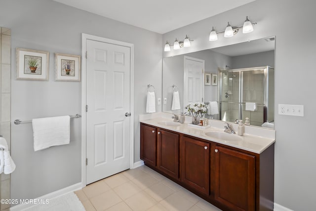 full bath featuring double vanity, tile patterned flooring, a shower stall, and a sink