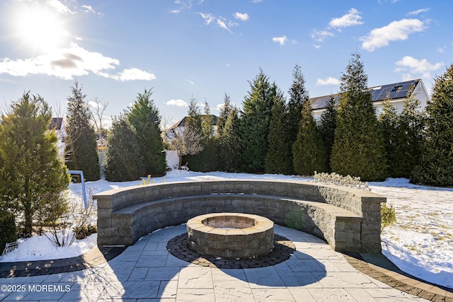 snow covered patio featuring an outdoor fire pit