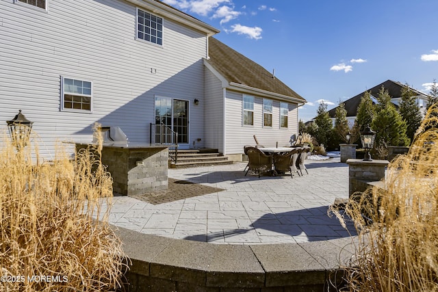 back of house featuring exterior bar and a patio area