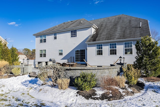 view of snow covered rear of property