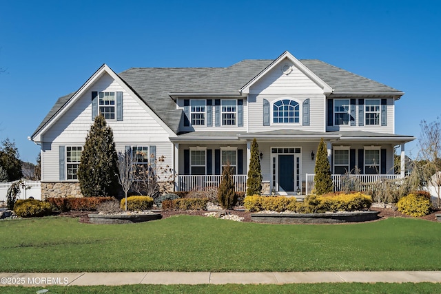 view of front facade with a porch, stone siding, and a front lawn