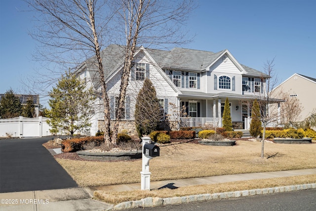 view of front of home featuring covered porch, fence, and a gate