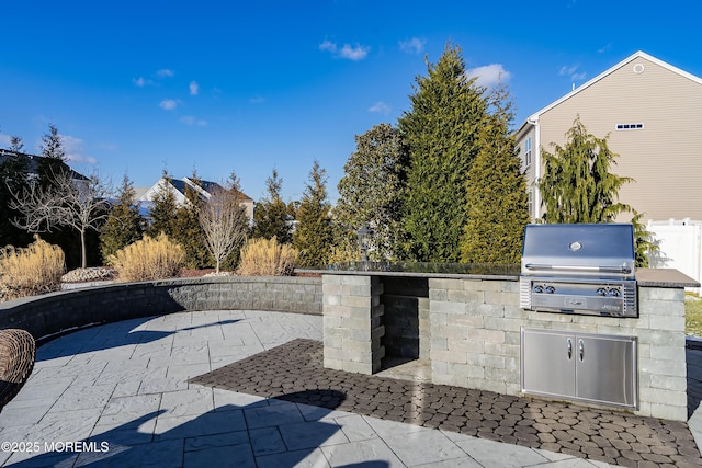 view of patio / terrace with exterior kitchen, fence, and grilling area