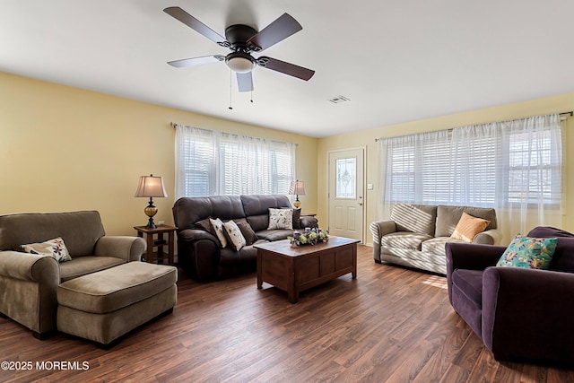 living room featuring ceiling fan and dark hardwood / wood-style floors