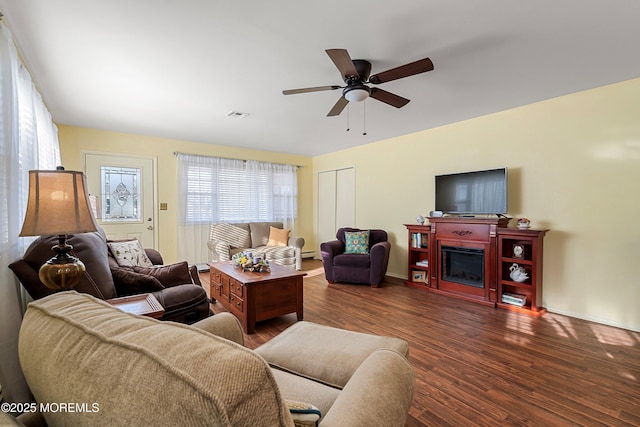 living room featuring ceiling fan and dark hardwood / wood-style flooring