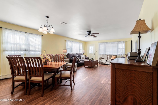 dining area with dark hardwood / wood-style flooring and ceiling fan with notable chandelier