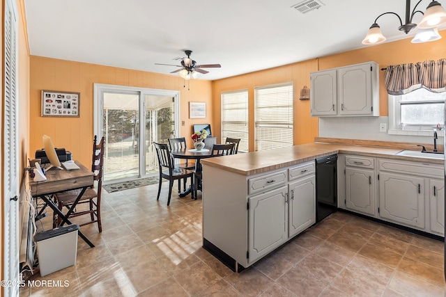 kitchen featuring ceiling fan, kitchen peninsula, sink, black dishwasher, and hanging light fixtures