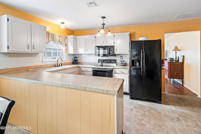 kitchen with white cabinetry, kitchen peninsula, and black appliances