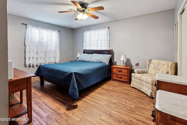 bedroom with ceiling fan, light wood-type flooring, and multiple windows