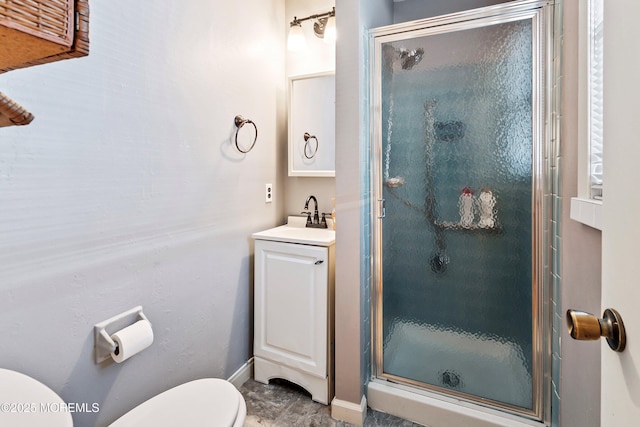 bathroom with toilet, vanity, and a shower with door