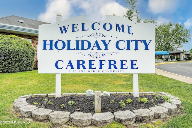 community / neighborhood sign featuring a lawn