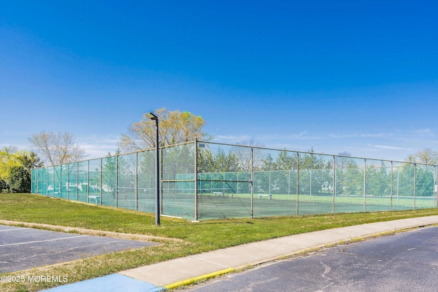 view of tennis court with a lawn