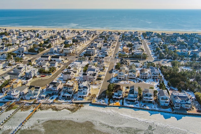 drone / aerial view featuring a water view and a view of the beach