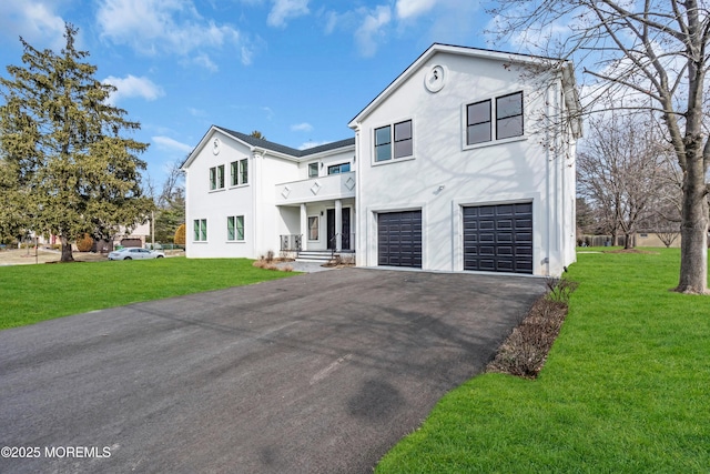 view of front of home with aphalt driveway, a front yard, a garage, and stucco siding