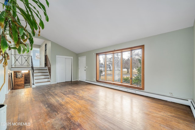 unfurnished living room with wood-type flooring, baseboard heating, and lofted ceiling